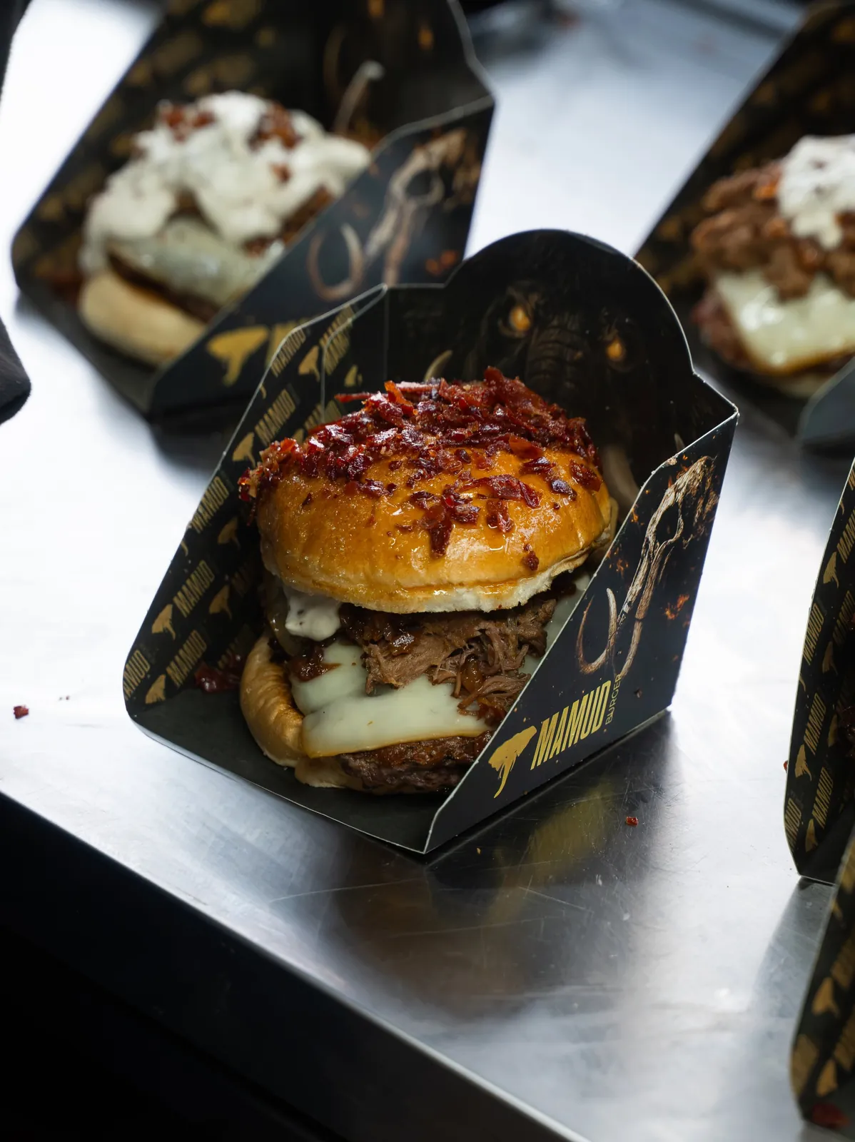 Burgers Eternal en cajas negras y doradas de Mamud